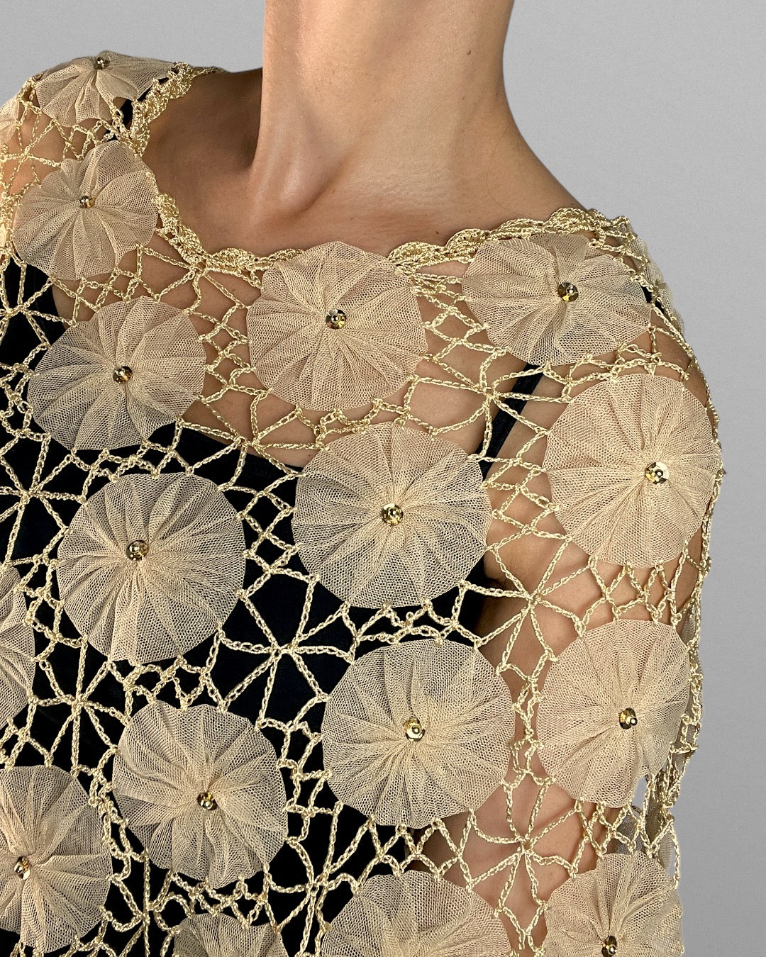 Virkad poncho med blomdetaljer